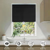 Cordless retractable roller shades in black providing light protection and noise reduction for a window.