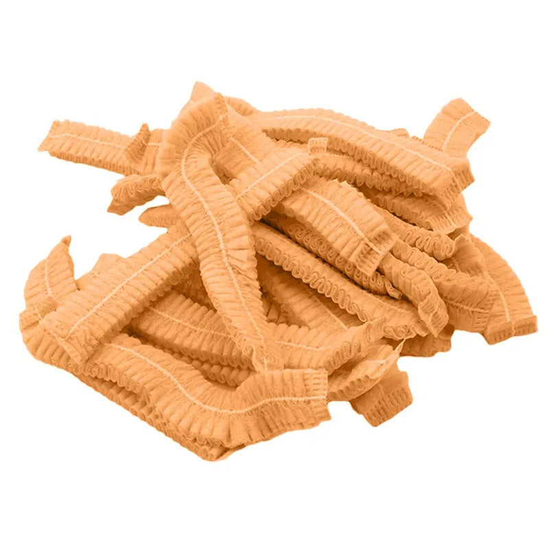 A pile of tan disposable non-woven hair net caps.