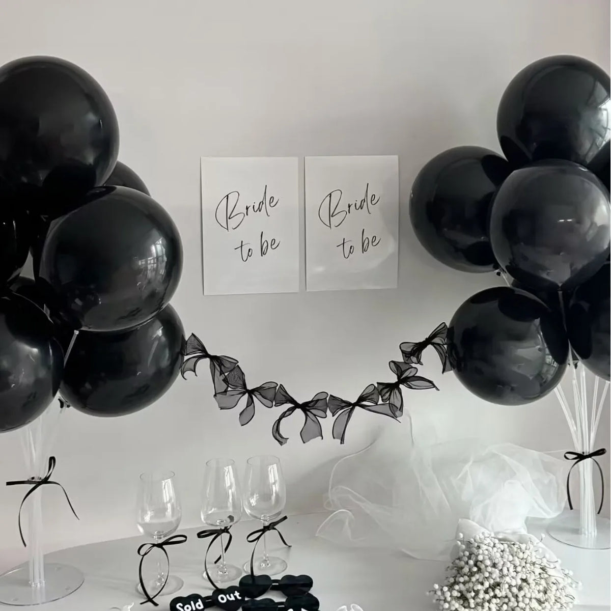 Black balloons tied with black ribbon forming a garland display