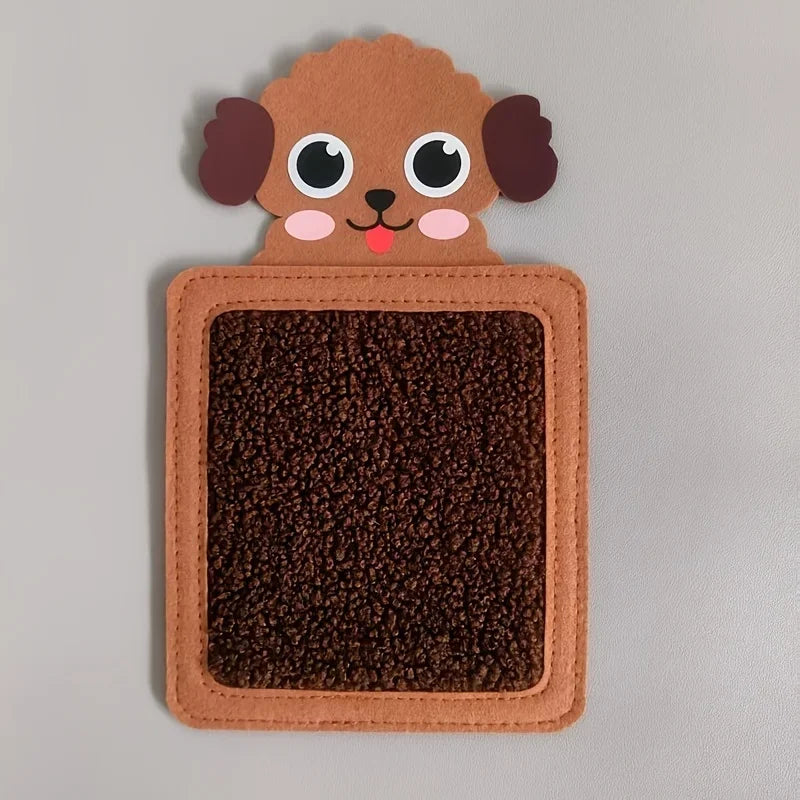An adorable brown dog face made of felt sits above a square, dark brown sensory mat.