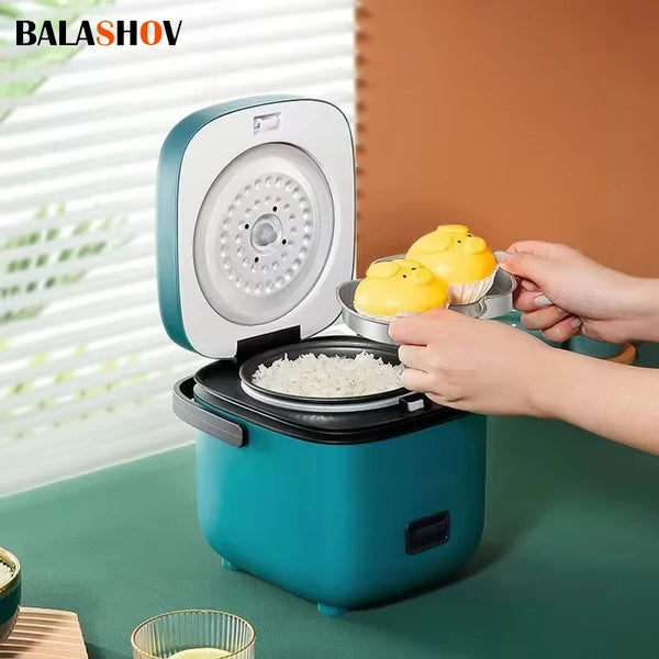 Una mano está colocando muffins amarillos en una olla arrocera eléctrica compacta con tapa verde azulada.