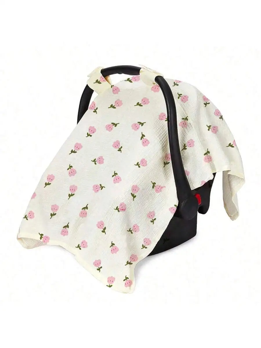 A white breathable stroller cover with pink floral patterns and a black strap.