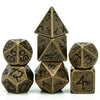 A set of seven metal polyhedral dice with a dragon font design arranged in a pyramid and surrounding cubes.