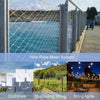 A view of a wire rope mesh system with a blue water background, clothlines, supporting string, and string lights.