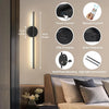 A set of rechargeable LED wall sconces with remote control and various functions shown on a bedside table.