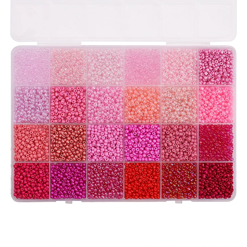 A storage box filled with various shades of pink, red, and purple acrylic rice beads in a 24-grid arrangement.