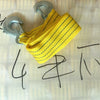 A yellow heavy-duty vehicle recovery towing strap with metal clasps is shown on a light background.
