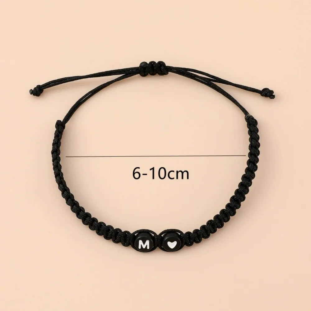 Black beaded bracelet with a heart initial charm and a measurement line indicating 6-10cm length.