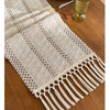 Beige boho table runner with tassels hand-woven farmhouse style displayed on a wooden table.