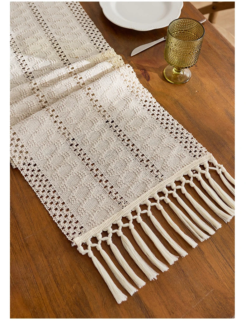 Beige boho table runner with tassels hand-woven farmhouse style displayed on a wooden table.
