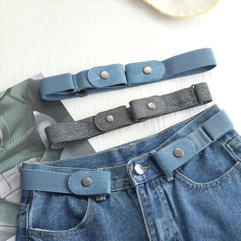 A close-up of a blue stretch elastic belt with dark gray buckle and a matching belt worn on denim jeans.