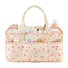 A light pink floral diaper organizer bag with multiple compartments and a curved handle.