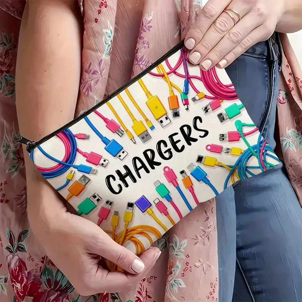 A hand holds a canvas charger storage pouch filled with various electronic charging cables and adapters.