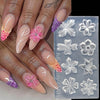 A hand displays various floral silicone nail art molds in shades of pink and purple.