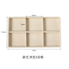 A rectangular beige velvet jewelry organizer tray with six detachable compartments.