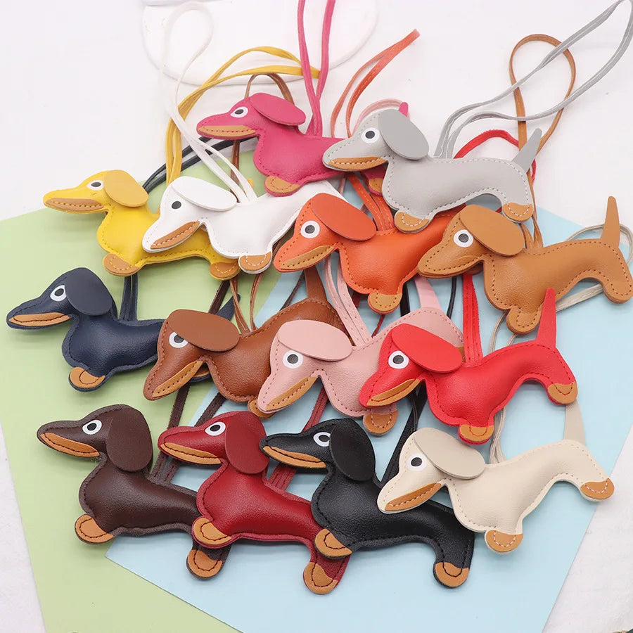 A collection of dachshund-shaped PU leather keychains in various colors like pink, orange, gray, and yellow.