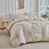A beige three-dimensional pleated floral duvet cover set displayed on a bed against a white paneled wall.