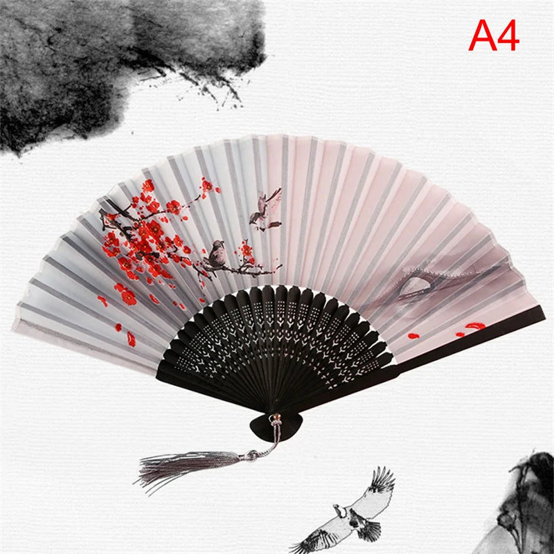 A folding fan with pink and white stripes featuring red floral designs on the surface.