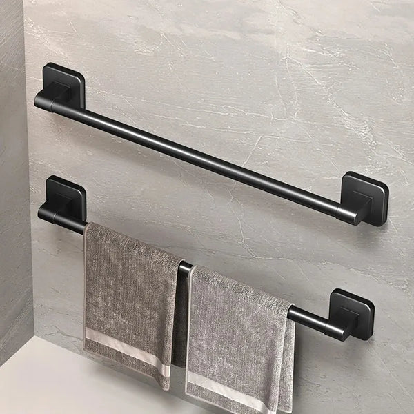 A black wall-mounted towel rack with a horizontal bar and two hanging gray towels mounted on a light gray wall.