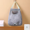 A gray mesh garbage bag holder is mounted on a wall with light blue fabric loops for hanging.