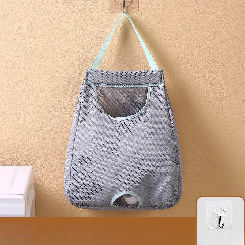 A gray mesh garbage bag holder is mounted on a wall with light blue fabric loops for hanging.