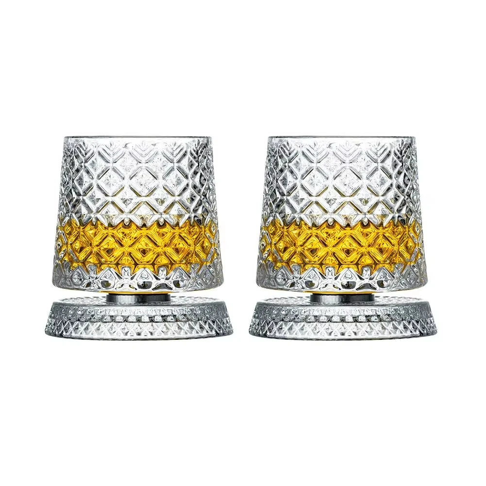 Ein Set aus zwei strukturierten silbernen Whiskeygläsern mit goldfarbener Innenseite und passenden Untertellern.