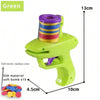 A green foam disc launcher toy with a colorful cylinder and an EVA soft bomb, shown next to a pile of colored discs.