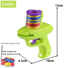 A green foam disc launcher toy with a colorful cylinder and an EVA soft bomb, shown next to a pile of colored discs.