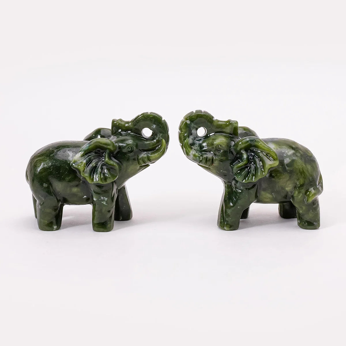 A pair of hand-carved natural jade elephant statues in green.