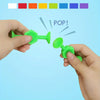 A hand is popping a green silicone suction bath toy for toddlers, demonstrating its use.