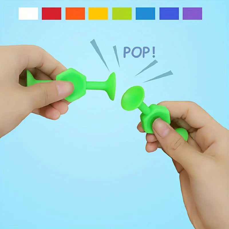 A hand is popping a green silicone suction bath toy for toddlers, demonstrating its use.
