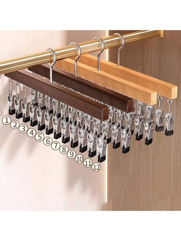 A wooden clip hanger with twelve metal clips is displayed on a light wood background.