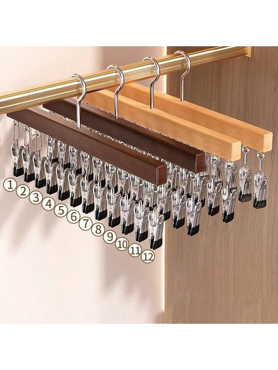 A wooden clip hanger with twelve metal clips is displayed on a light wood background.