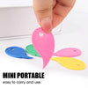 A hand is holding a pink mini portable plastic box cutter or letter opener alongside blue, green, and yellow versions.
