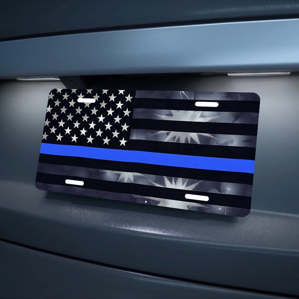 A thin blue line American flag metal sign displayed on a gray surface.