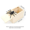 A wooden box containing a black spider, used as a surprise or prank item.