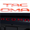 A set of orange 3D letter emblems for a Toyota Tacoma tailgate, spelling out TACOMA.