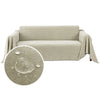 A beige waterproof anti-slip sofa cover with a tassel hem draped over a sofa.