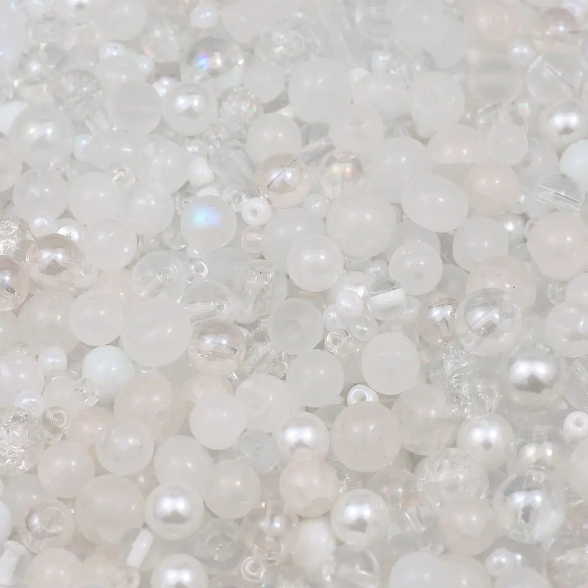 A close-up view of mixed sizes clear and milky white glass beads for jewelry making.