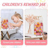 A pink and yellow wooden reward jar with a floral design is shown next to a child writing their name.