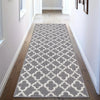 A geometric runner rug with a pattern of interlocking diamonds in navy and grey sits on a wooden floor.