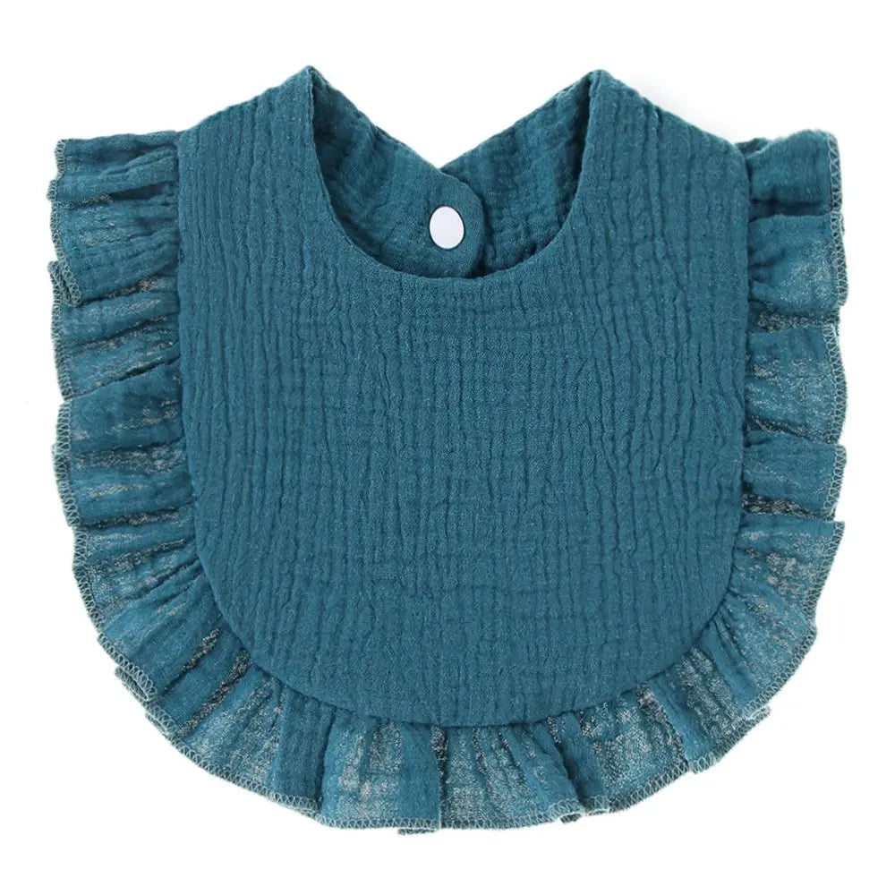 A teal knitted baby bib with ruffled edges and a small button closure.