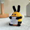 Handmade crochet bee kind doll with black and yellow yarn, featuring a sign that says bee kind whenever possible but sting li