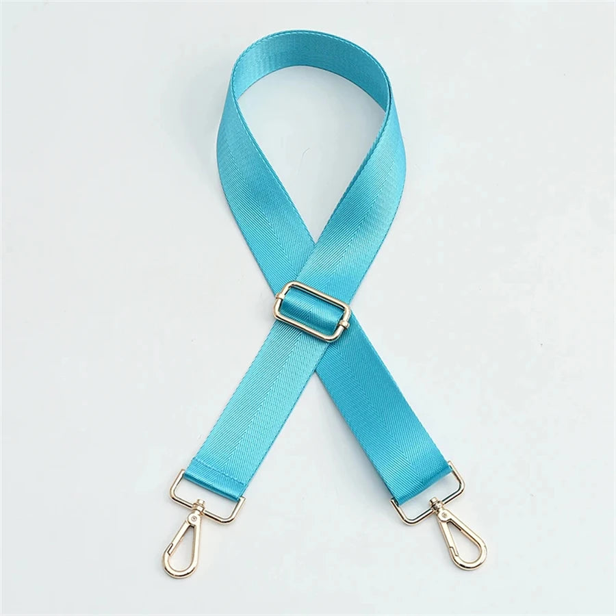 A turquoise nylon bag strap with a gold buckle shown in an 'X' shape.