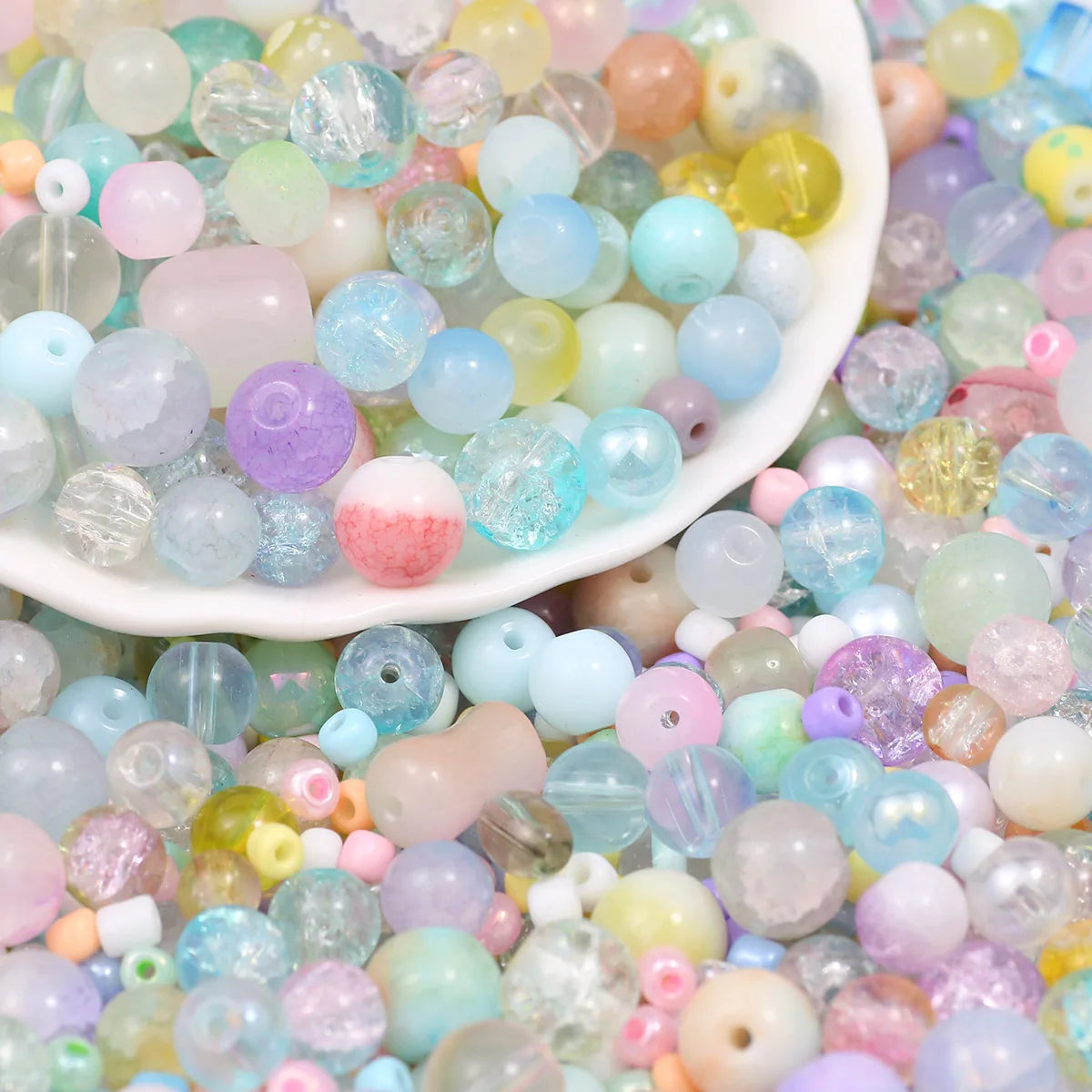 A close-up view of mixed sizes and colors of clear, iridescent glass beads for jewelry making.