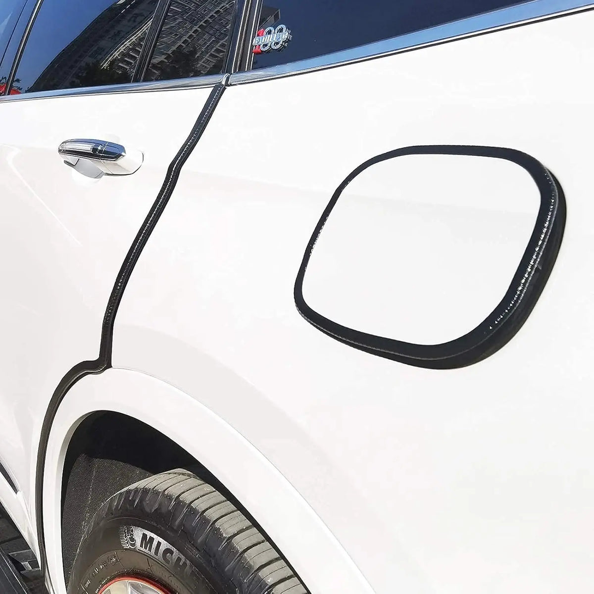 Black U-shaped rubber edge trim with a metal core installed on the side of a white car door.
