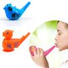 An orange plastic bird whistle toy is shown being blown by a person.