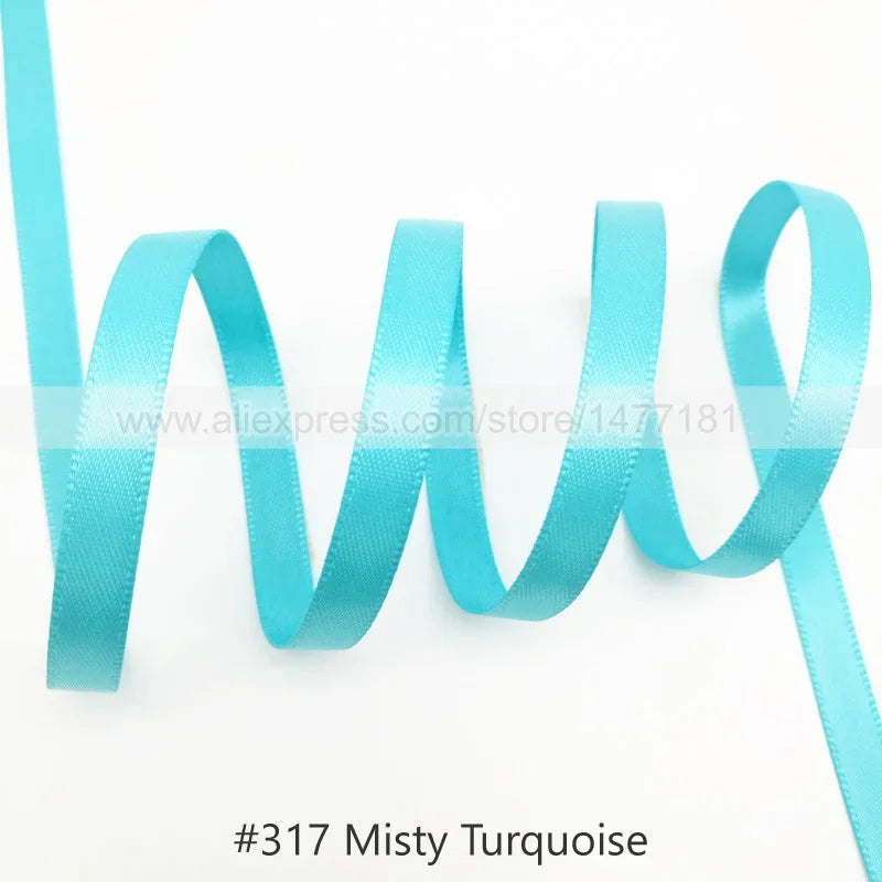 Light blue satin ribbon in a misty turquoise color shown in a wavy drape.
