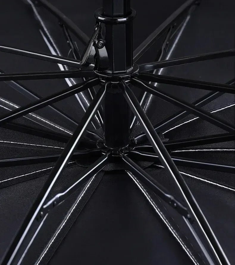 Close-up view of a black foldable windshield sunshade with a spoked design.