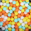 A large pile of colorful plastic balls in various shades of orange, yellow, and light blue.